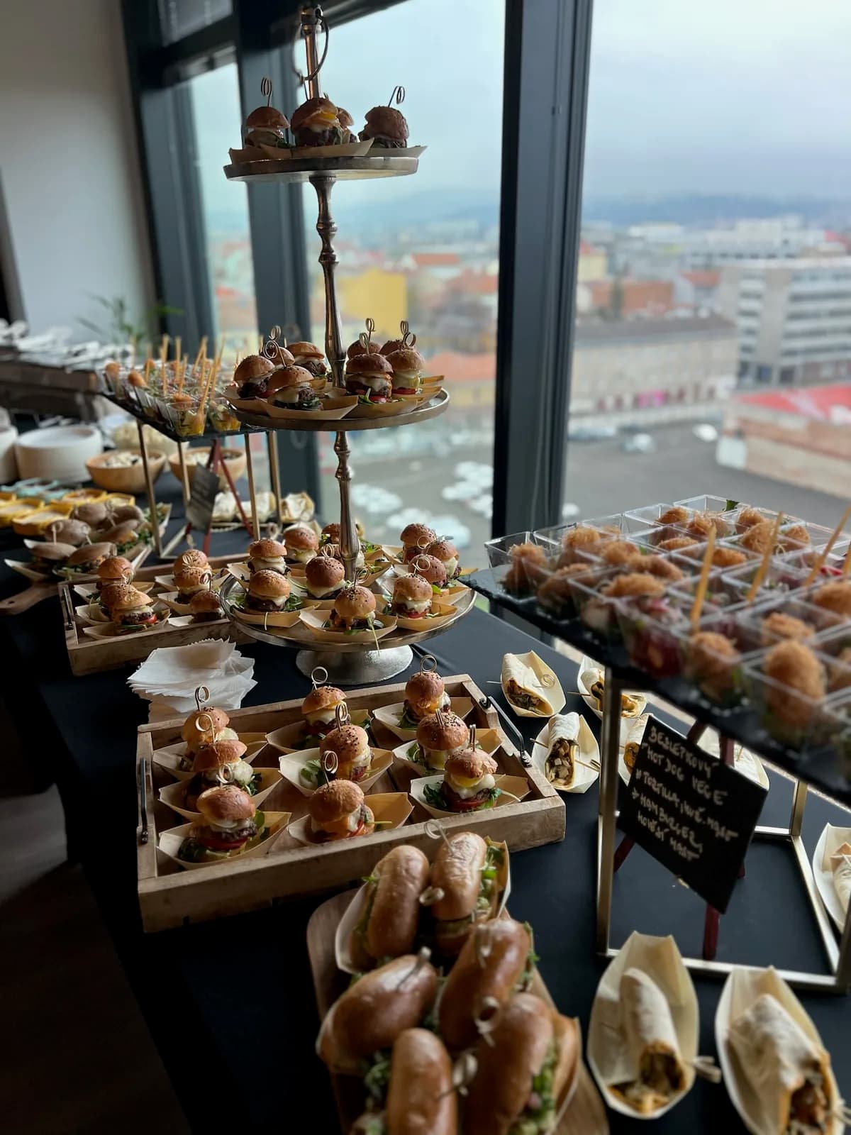 Etažérka s mini burgery na firemní akci v prosklené kanceláři